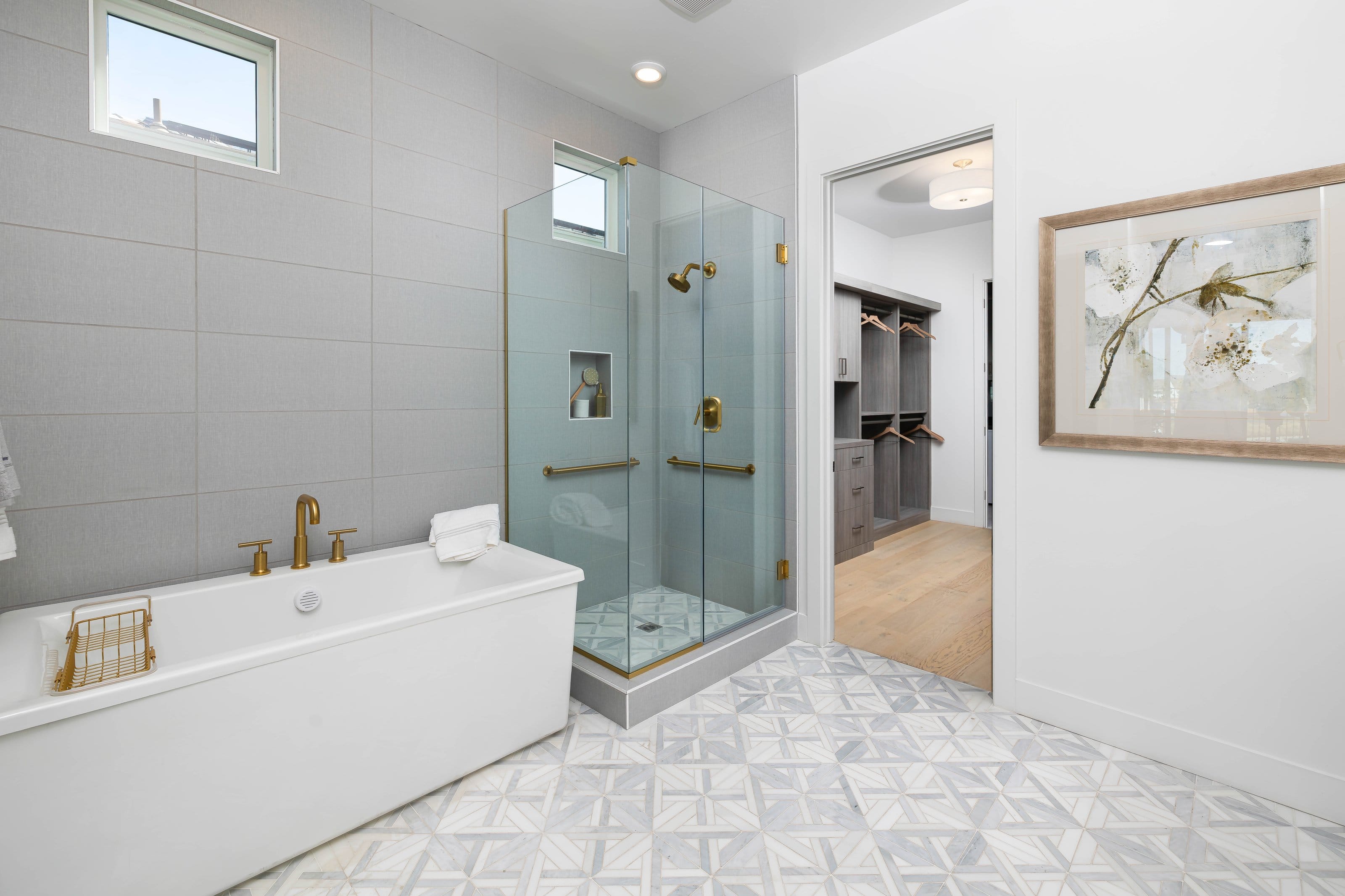 Mitered glass corner detail on a frameless shower with gold hardware
